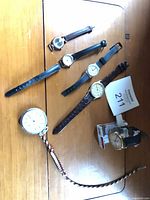 Group shot of all seven watches laid out on wooden surface