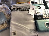 Overall lot showing packaged curtain panels and swags with tag 153