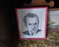 Portrait in frame positioned against furniture showing overall artwork and frame