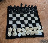 Complete oversized chess set arranged on faux fur board showing all pieces