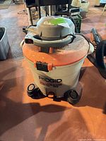 Front view of Ridgid wet/dry vacuum showing caster base and logo