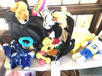 Overall lot showing Sherpa carrier with various plush and rubber toys on and around it