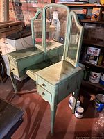full view of vanity showing green finish, tri-fold mirror, drawers, legs