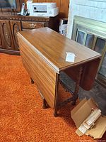 Table with one leaf down showing top surface and spindle legs