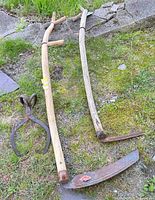 Overall view of both scythe snaths and ice tongs on ground