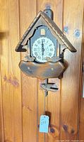 Front view of the cuckoo clock mounted on wood panel wall
