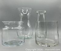 Group view of four clear glass vases
