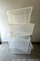 Four clear plastic bins stacked showing translucency and absence of lids