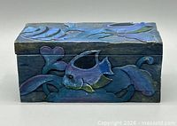 Front view of carved wood box showing fish motif