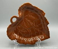 Front view of brown ceramic leaf tray showing overall form and glaze