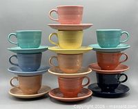 Stacked view of all ten coloured cup and saucer sets