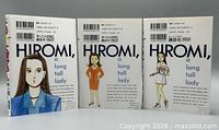 Front view of three manga volumes showing English synopsis side