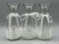 Front view of three lace-trimmed glass carafes showing LOVE embossing