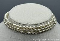 Choker on stand showing triple-strand design and overall appearance
