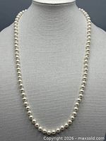 Full view of faux pearl necklace displayed on bust