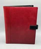 Front view of red leather portfolio with black tab