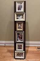 Front view showing six matted photo openings in tall wood-tone frame