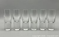 Front view of six clear heavy-base shot glasses