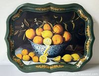 Front view of green scalloped metal tray with citrus still life image