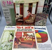 All six magazines standing and laying to show variety of covers