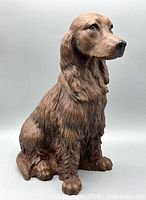 Full front-left view of seated dog sculpture