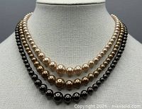 Necklace displayed on bust highlighting triple strands and colour gradient