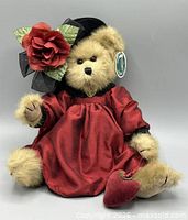 Front view of bear seated showing dress, hat, heart accessory, hang tag