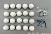 Top view of 20 white ceramic knobs arranged in rows with screws beside them