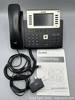 Phone base, handset, coiled cord, power adapter and quick start guide grouped