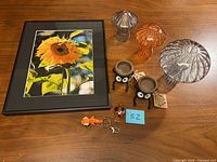 Group view of framed print, three glass mushrooms, two planters, metal figurine and fish keychain