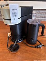 Front view of espresso machine and milk frother showing overall appearance and power cords