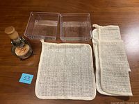 Entire lot laid out: brush in metal stand with soap, two plastic dishes, square pad, two folded cloths