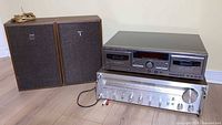 Akai receiver, JVC cassette deck stacked with two Sanyo speakers and loose wire