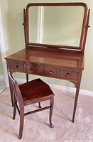 front view of mahogany vanity with mirror and chair