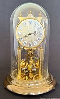 Front view of assembled Kern torsion clock under glass dome