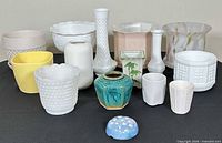 Group shot of all 15 vases and planters displaying variety of shapes, sizes, colours and materials