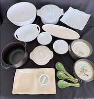 All dinnerware pieces and pot arranged on surface