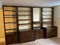 Full view of modular wall system assembled showing shelving towers and base storage units