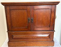 Front view closed showing cabinet design, brass pulls
