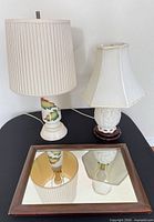 Two table lamps with shades and wood-framed mirror displayed together