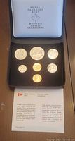 Open case showing all seven coins and information card