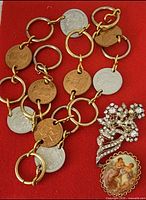 Coin belt with two brooches on red background