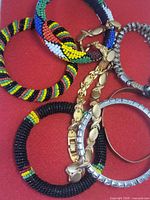Group view of bangles, bracelets and necklace on red background