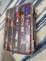 Top view of case showing compartmentalized trays filled with diecast vehicles