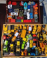 Top view of two wooden trays filled with assorted diecast vehicles