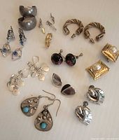 Group shot of all eleven earring pairs arranged on surface