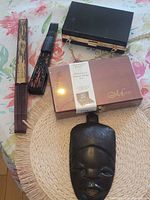 All lot items laid out: mask, calligraphy set box, clutch, two fans