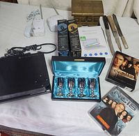 Group shot showing Sony player, DVD sets, UV sanitizer box, goblet set, knives, brass box, baby monitor system