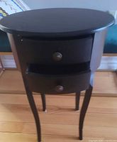 Front view showing oval top, both drawers, knobs, and legs