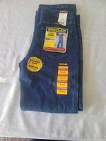 Folded jeans with hangtags and size stickers visible